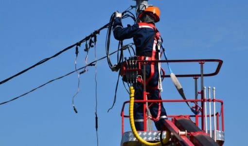 Utility worker fixing electricity power lines